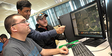 Cayuga instructor helping students in the GIS lab