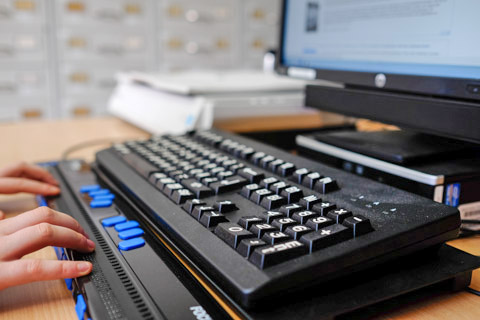Student using a braille keyboard and other assistive technology