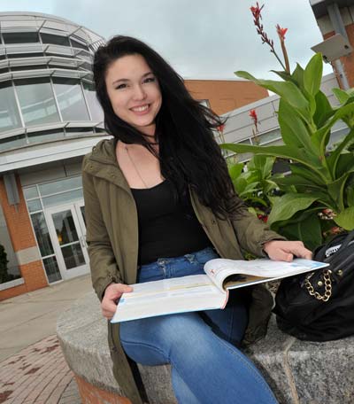 Student reading a book outside the Auburn campus