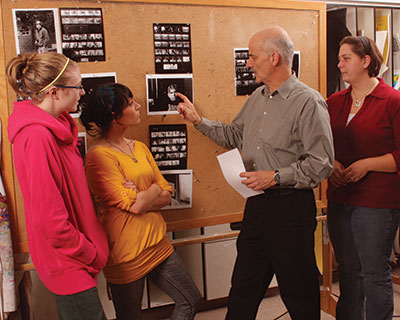 Art professor showcasing other students artwork on the board