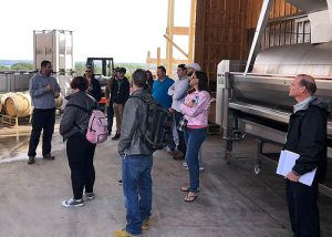 Students at the Buttonwood Grove Winery insde the barn where the wine is produced